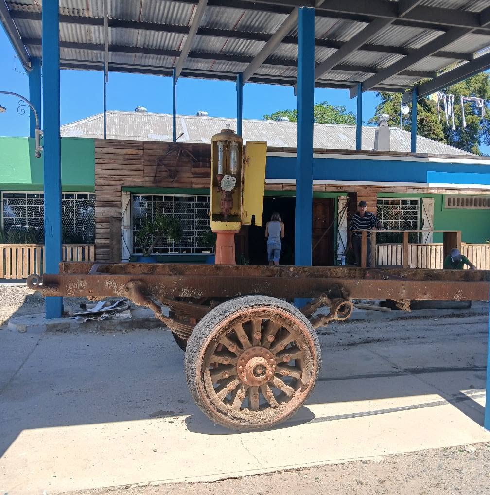 Shop exterior with vintage cart and old fuel pump